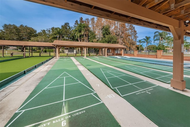 surrounding community featuring fence and shuffleboard