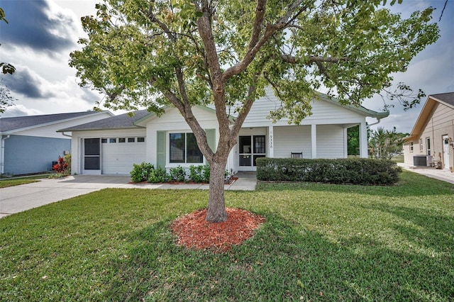 ranch-style home featuring an attached garage, a front lawn, central air condition unit, and driveway