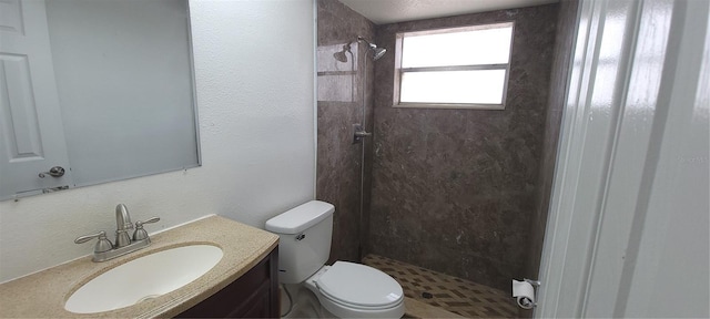 bathroom featuring a shower stall, toilet, and vanity