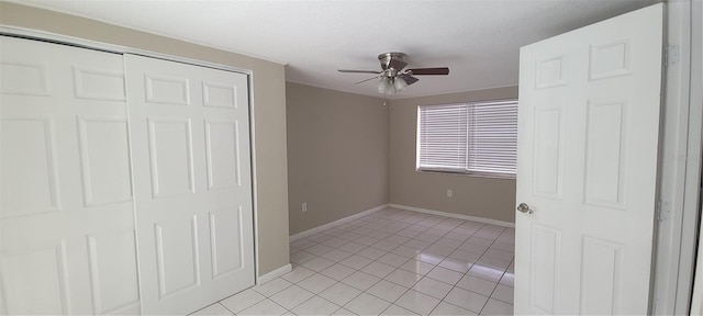 unfurnished bedroom with ceiling fan, baseboards, a closet, and light tile patterned floors