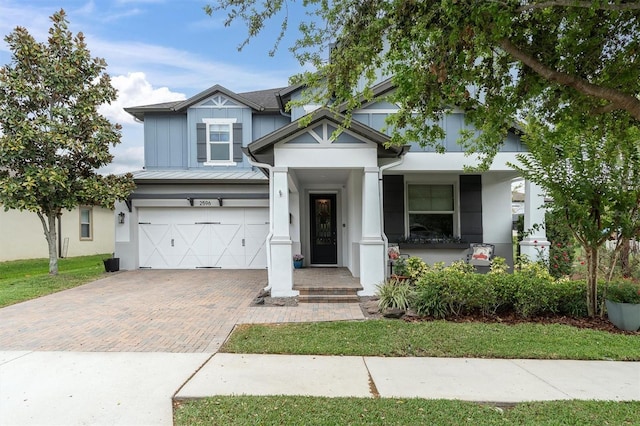 view of front of property featuring decorative driveway, an attached garage, and stucco siding