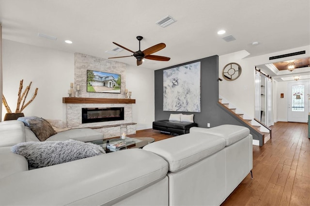 living area with a fireplace, wood-type flooring, visible vents, ceiling fan, and recessed lighting