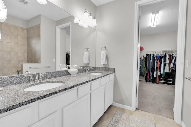 full bathroom with double vanity, a sink, and tile patterned floors