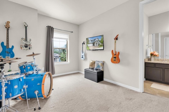 miscellaneous room with baseboards, a sink, and carpet