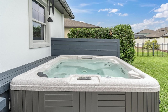 view of patio / terrace with a hot tub and fence