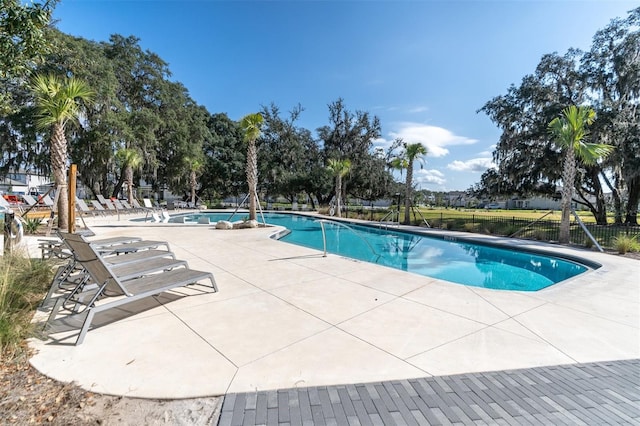 community pool with fence and a patio area