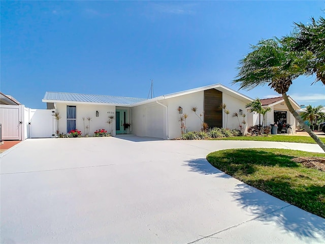 4936 Dory Dr, New Port Richey, FL 34652 - view of front of home featuring stucco siding, a gate, and curved driveway