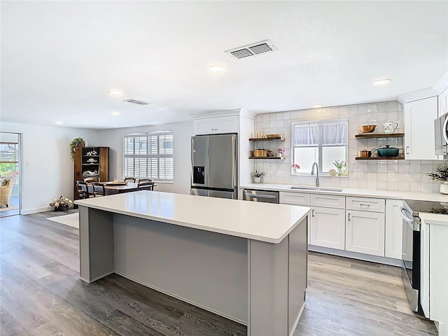 4936 Dory Dr, New Port Richey, FL 34652 - kitchen featuring a sink, stainless steel appliances, open shelves, and visible vents