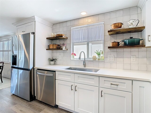 4936 Dory Dr, New Port Richey, FL 34652 - kitchen with open shelves, decorative backsplash, a sink, light wood-style flooring, and appliances with stainless steel finishes