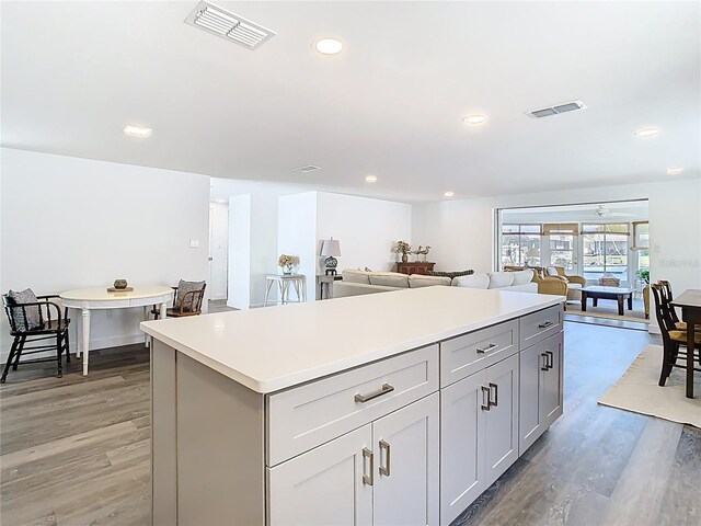 4936 Dory Dr, New Port Richey, FL 34652 - kitchen with light countertops, visible vents, a kitchen island, and light wood finished floors