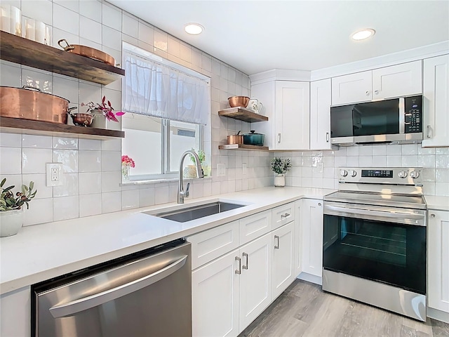 4936 Dory Dr, New Port Richey, FL 34652 - kitchen featuring light countertops, tasteful backsplash, appliances with stainless steel finishes, a sink, and open shelves