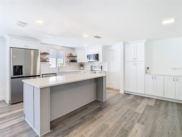 4936 Dory Dr, New Port Richey, FL 34652 - kitchen with visible vents, open shelves, a sink, and stainless steel appliances