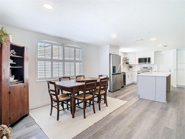 4936 Dory Dr, New Port Richey, FL 34652 - dining space featuring baseboards, recessed lighting, and light wood-type flooring