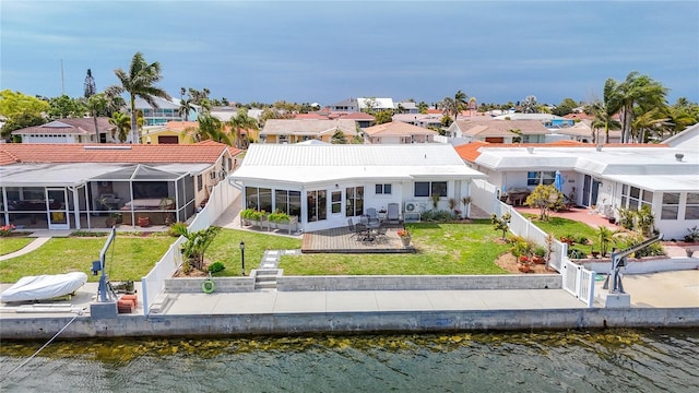 4936 Dory Dr, New Port Richey, FL 34652 - back of property featuring a fenced backyard, a residential view, a water view, and a lawn