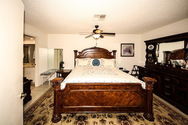 9321 Whitstone Ct, New Port Richey, FL 34655 - bedroom with connected bathroom, visible vents, light tile patterned floors, and a textured ceiling