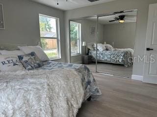 bedroom featuring a closet, wood finished floors, and ceiling fan