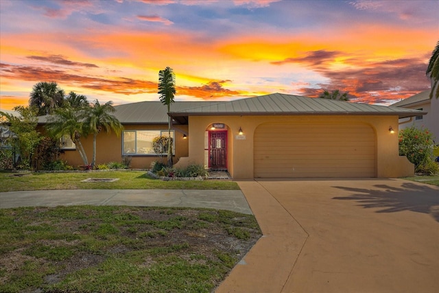 view of front of property featuring a front yard, concrete driveway, stucco siding, and an attached garage