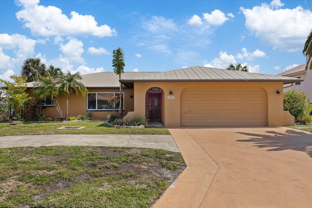 5000 Southshore Dr, New Port Richey, FL 34652 - view of front of property featuring driveway, an attached garage, stucco siding, a front yard, and a metal roof