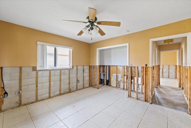 5000 Southshore Dr, New Port Richey, FL 34652 - empty room with a ceiling fan, light tile patterned floors, and a wainscoted wall