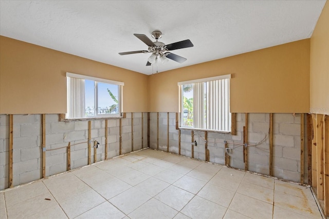 5000 Southshore Dr, New Port Richey, FL 34652 - empty room with wainscoting, light tile patterned floors, tile walls, and ceiling fan