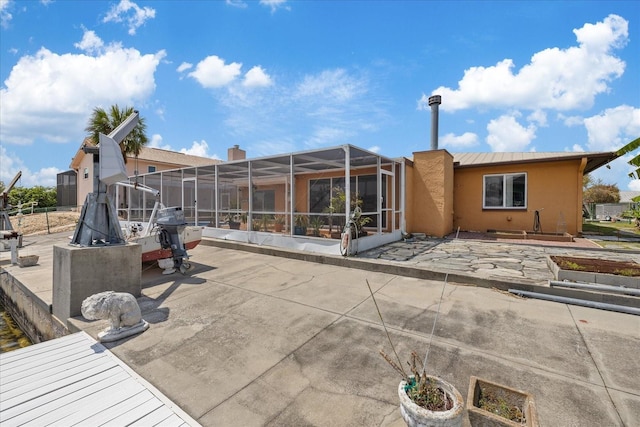 5000 Southshore Dr, New Port Richey, FL 34652 - back of house with a patio, glass enclosure, and stucco siding