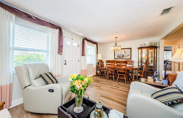 4107 Glissade Dr, New Port Richey, FL 34652 - living room featuring baseboards, visible vents, an inviting chandelier, and light wood-type flooring
