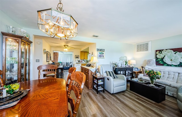 4107 Glissade Dr, New Port Richey, FL 34652 - dining room featuring ceiling fan with notable chandelier, light wood finished floors, and visible vents