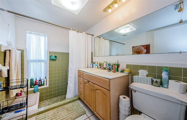 4107 Glissade Dr, New Port Richey, FL 34652 - full bath featuring vanity, a tile shower, tile walls, toilet, and tile patterned floors