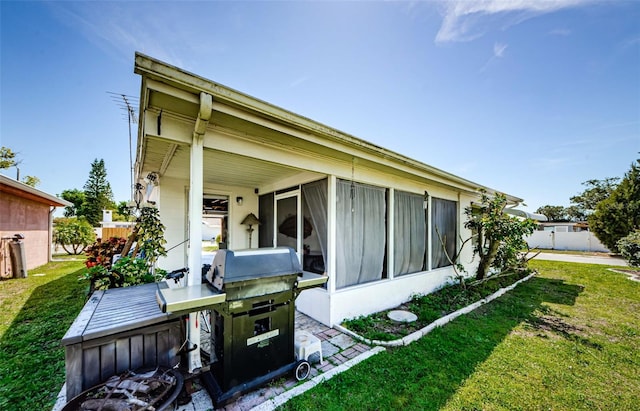 4107 Glissade Dr, New Port Richey, FL 34652 - back of house featuring a sunroom, fence, and a yard