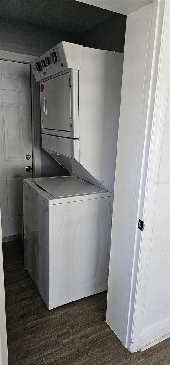 807 S Castle Ct, Tampa, FL 33612 - laundry area featuring dark wood-style flooring, stacked washer / drying machine, and laundry area