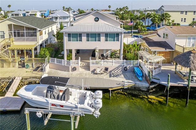 4058 Centavo Ct, Hernando Beach, FL 34607 - dock area with boat lift, a water view, a residential view, a fenced backyard, and a patio area