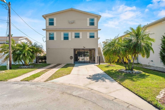 4058 Centavo Ct, Hernando Beach, FL 34607 - coastal inspired home with stairway, concrete driveway, and a front yard