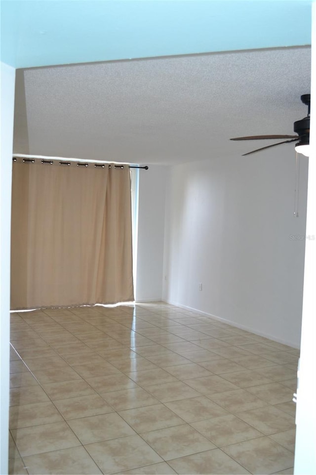 unfurnished room with a ceiling fan, a textured ceiling, and light tile patterned flooring