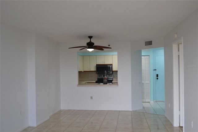 unfurnished living room featuring a ceiling fan and light tile patterned flooring