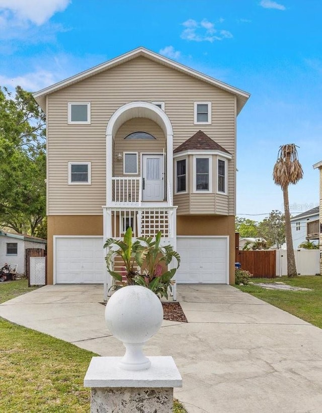 view of front of property featuring driveway, stucco siding, covered porch, and an attached garage