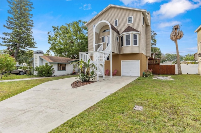 view of front of house with stairs, concrete driveway, fence, a front lawn, and a garage