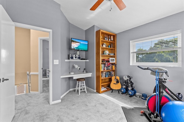 workout area featuring baseboards, lofted ceiling, carpet, and a ceiling fan