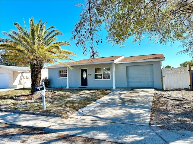 single story home featuring an attached garage, stucco siding, driveway, and fence