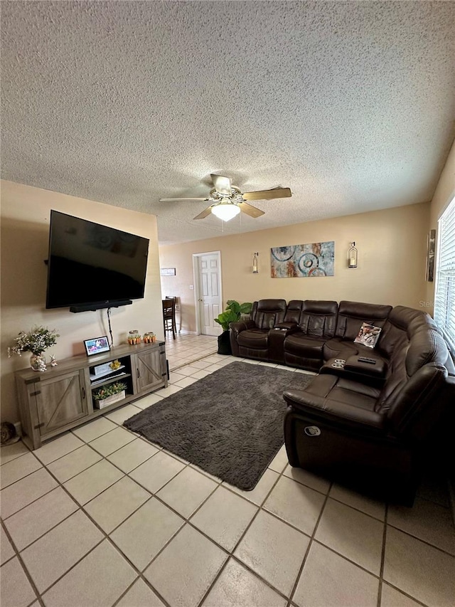 living room featuring light tile patterned floors, ceiling fan, and a textured ceiling