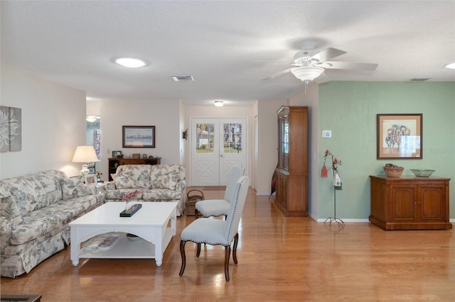 6530 Pine Meadows Dr, Spring Hill, FL 34606 - living room with a textured ceiling, light wood-style flooring, baseboards, visible vents, and ceiling fan