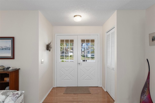 6530 Pine Meadows Dr, Spring Hill, FL 34606 - entryway featuring light wood-style flooring, baseboards, and a textured ceiling
