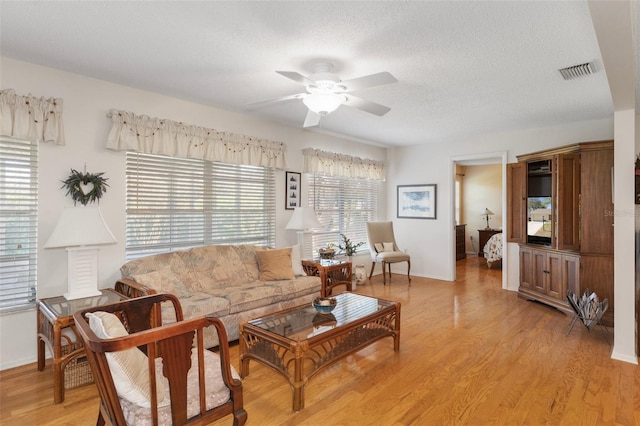 6530 Pine Meadows Dr, Spring Hill, FL 34606 - living area featuring baseboards, a textured ceiling, ceiling fan, light wood-style flooring, and visible vents