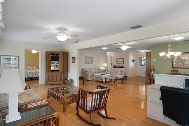 6530 Pine Meadows Dr, Spring Hill, FL 34606 - living area featuring ceiling fan with notable chandelier, visible vents, light wood-style floors, and a textured ceiling