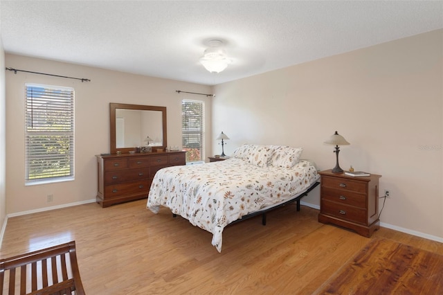 6530 Pine Meadows Dr, Spring Hill, FL 34606 - bedroom with baseboards, light wood-style flooring, and a textured ceiling