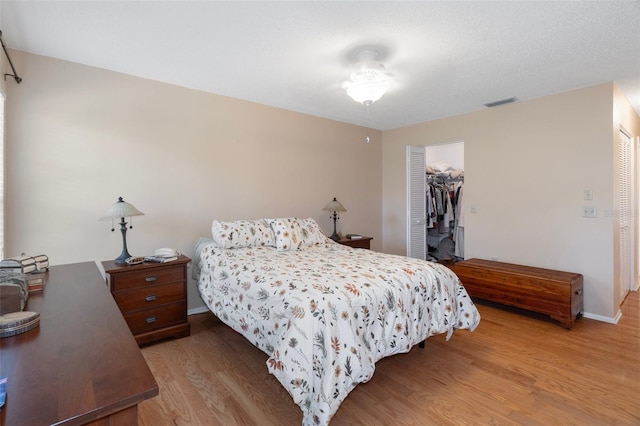 6530 Pine Meadows Dr, Spring Hill, FL 34606 - bedroom featuring a closet, visible vents, light wood finished floors, baseboards, and a walk in closet