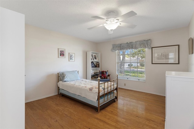 6530 Pine Meadows Dr, Spring Hill, FL 34606 - bedroom featuring baseboards, a textured ceiling, and light wood-style floors