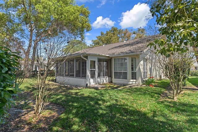 6530 Pine Meadows Dr, Spring Hill, FL 34606 - back of property with a lawn, a shingled roof, and a sunroom