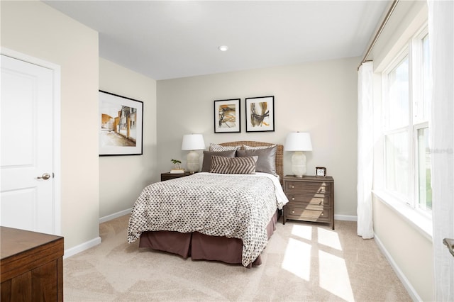 bedroom featuring baseboards and light colored carpet
