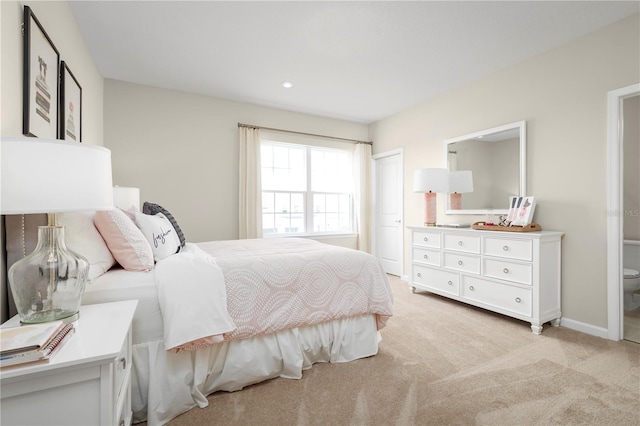 bedroom with light colored carpet, a closet, and baseboards