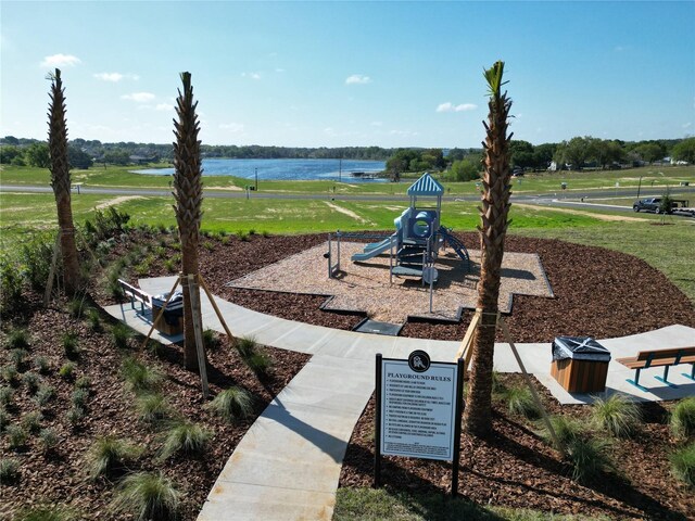 view of yard with playground community and a water view